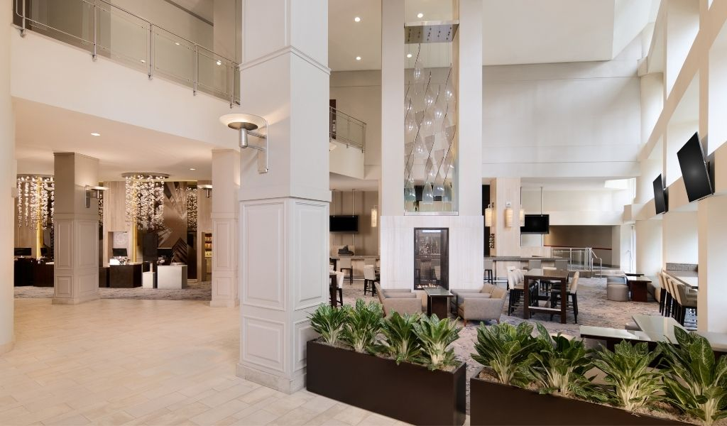 Bright two-story hotel lobby with lounge seating