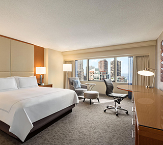 Guest room with king bed and city skyline view